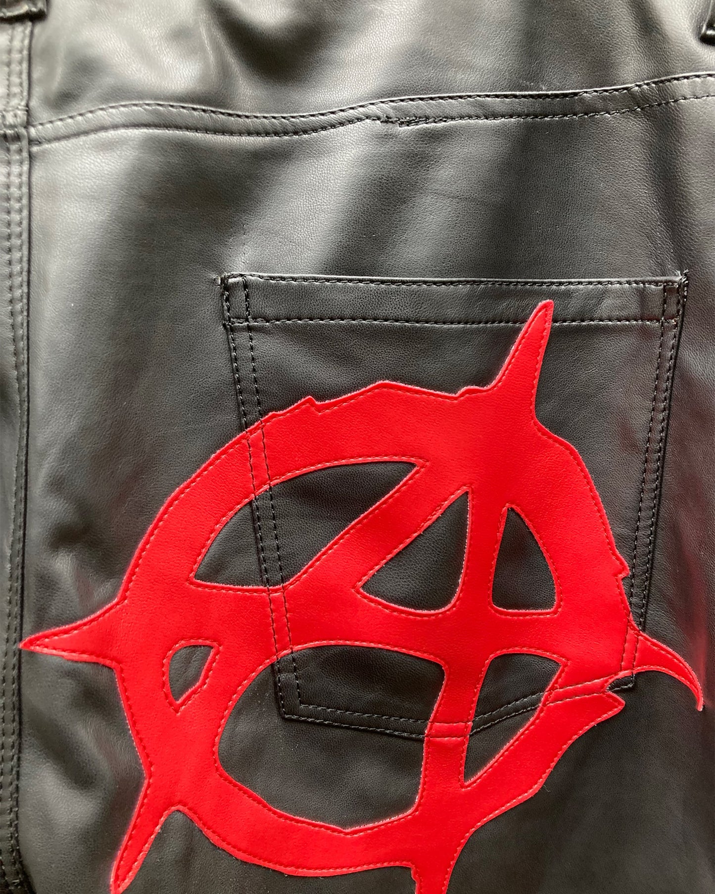 detail view of the back logo of the anarchy pleather pants