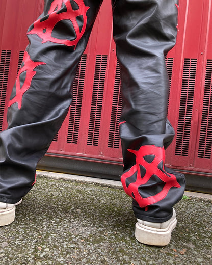 back detail of the logos of the anarchy pleather pants worn by a model